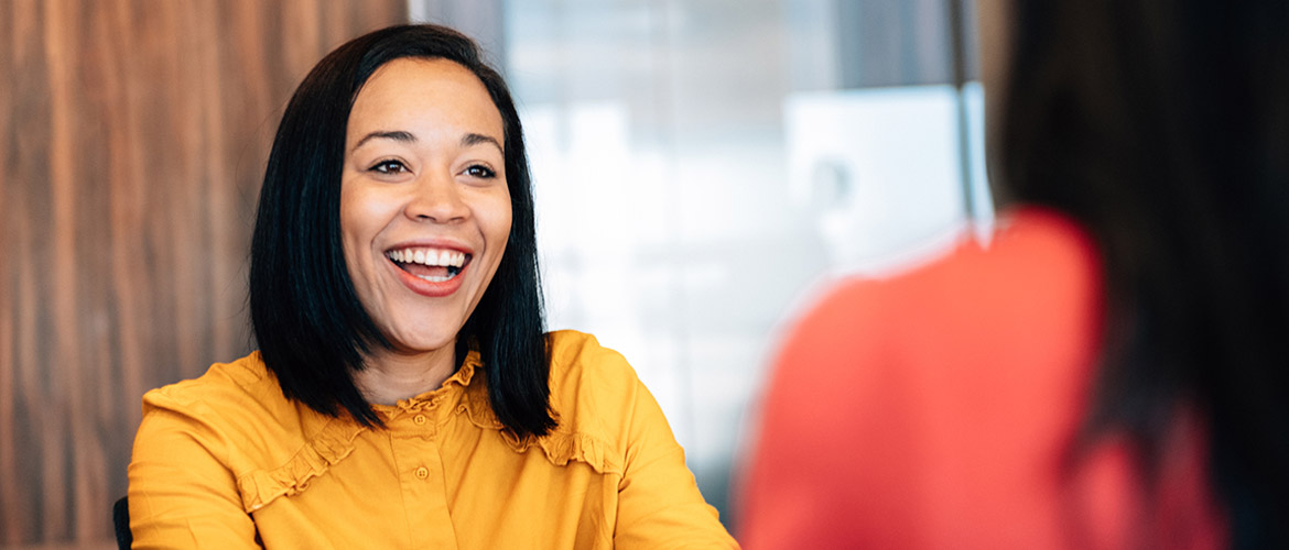 Woman smiling while talking to customer representative in office