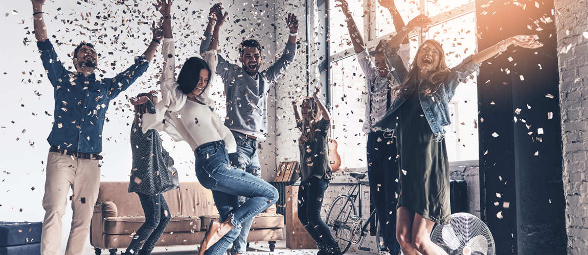 Group of people cheering with confetti falling down